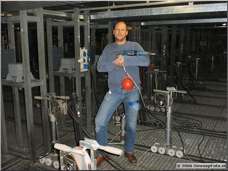 Foto 20-398. John Lankreijer op de lichtvloer; met boormachine.De bal voorkomt dat het gereedschap 9 meter naar beneden kan vallen